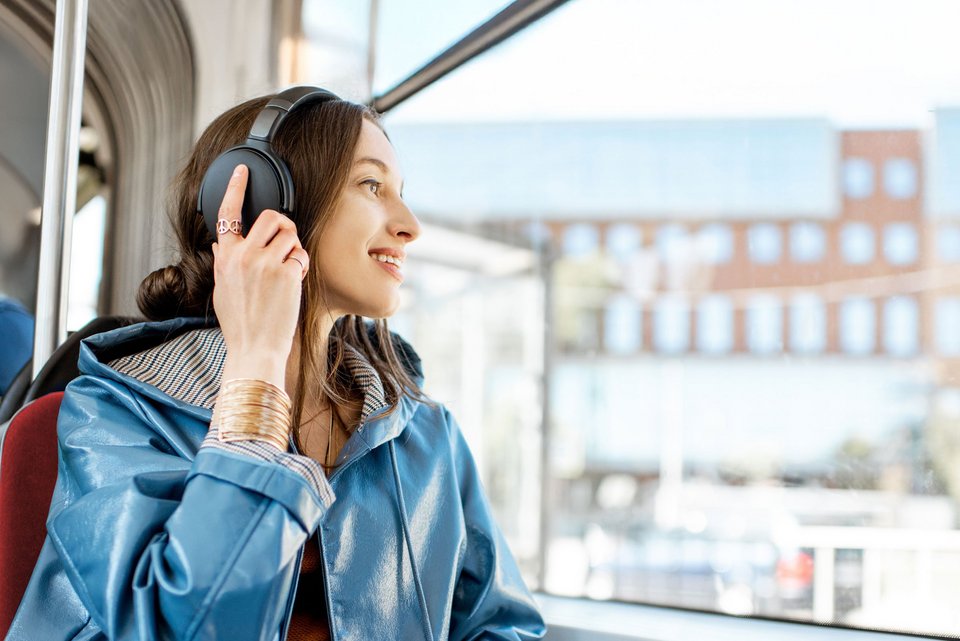 Frau mit Kopfhörer in einer Straßenbahn